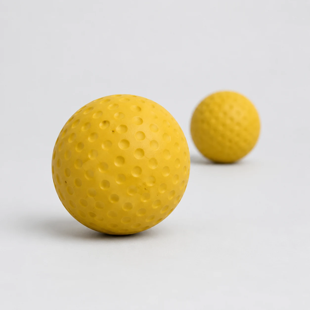 Solid rubber fetch ball for dogs on a neutral background