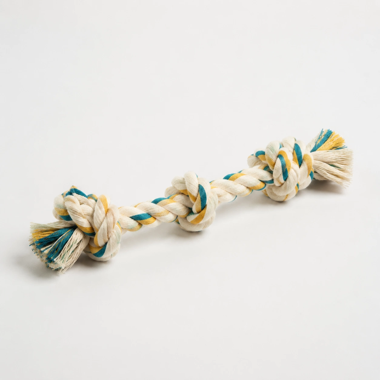 Knotted cotton rope tug toy on a neutral background