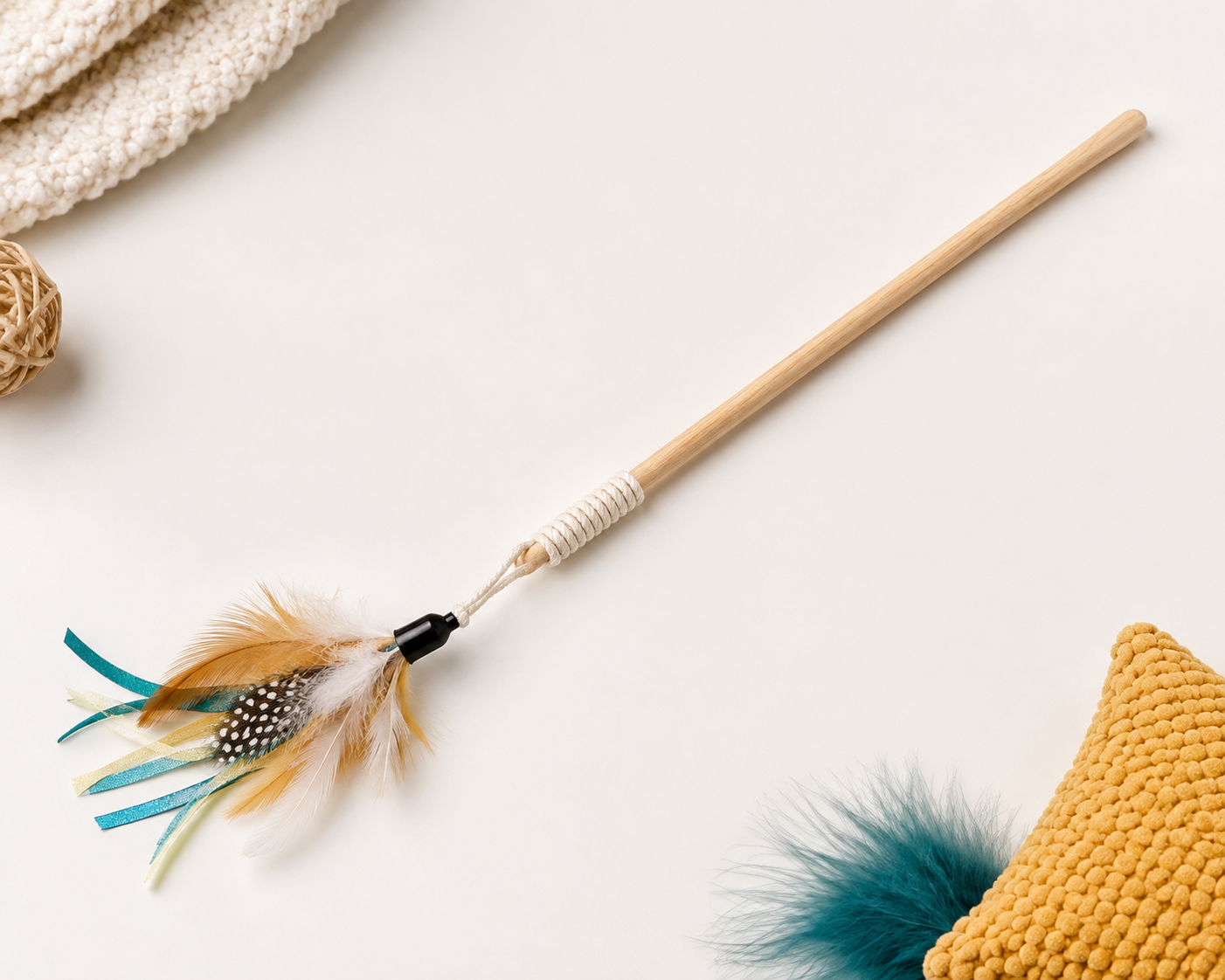Cat teaser wand with feather tip on a neutral background